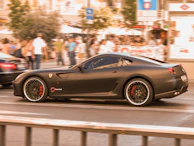 A matte black McLaren 720S speeding past Miami skyscrapers at dusk.