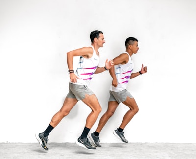 a couple of men running next to each other
