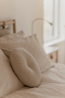 a bed with a white comforter and pillows
