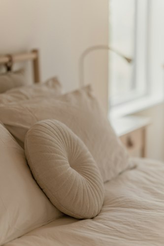 Close-up of a hand pressing into a folded pillow to test its firmness and support
