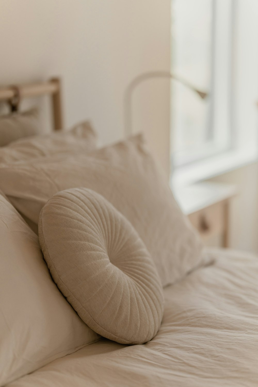 a bed with a white comforter and pillows