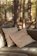 A cozy outdoor chaise lounge bathed in warm afternoon sunlight with a soft throw pillow.