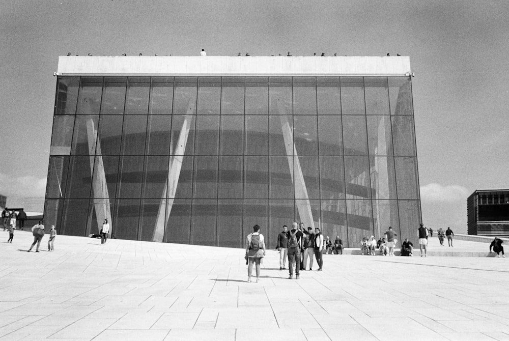 a group of people standing outside of a large building