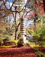 A serene temple garden in autumn with golden leaves and traditional architecture.