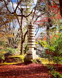 A serene temple garden in autumn with golden leaves and traditional architecture.