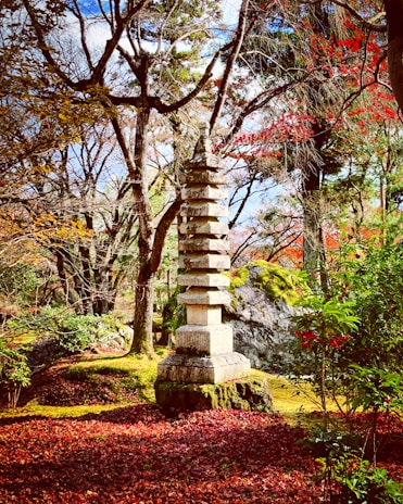 A serene temple garden in autumn with golden leaves and traditional architecture.