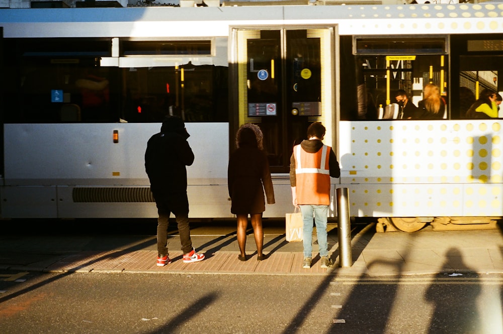 a group of people standing next to a train