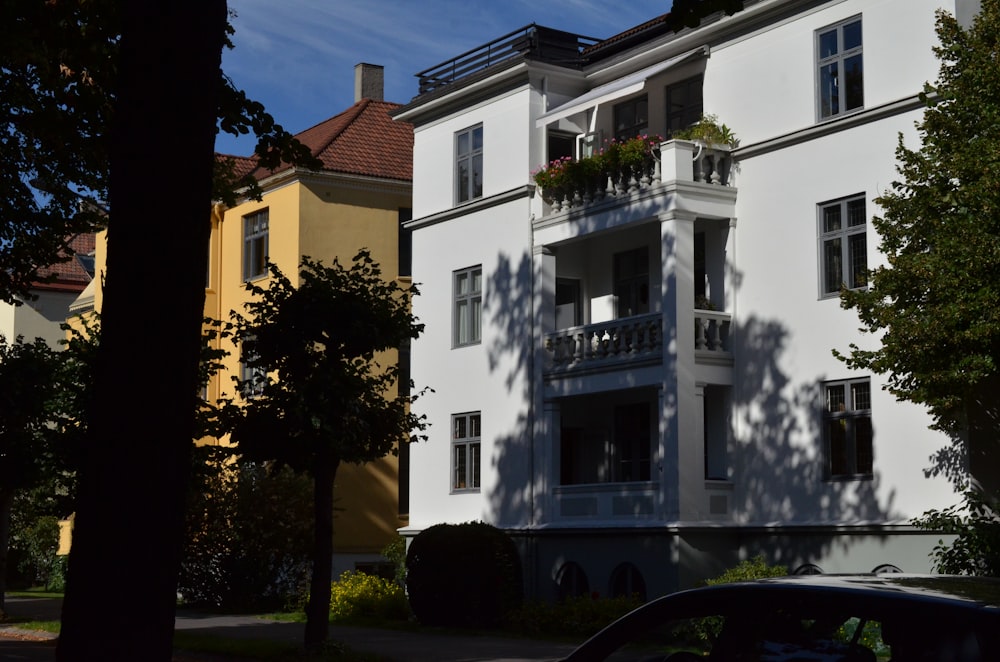 a car parked in front of a tall white building