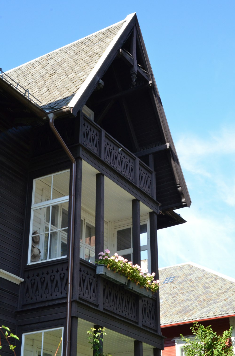 a black house with a balcony and flower boxes