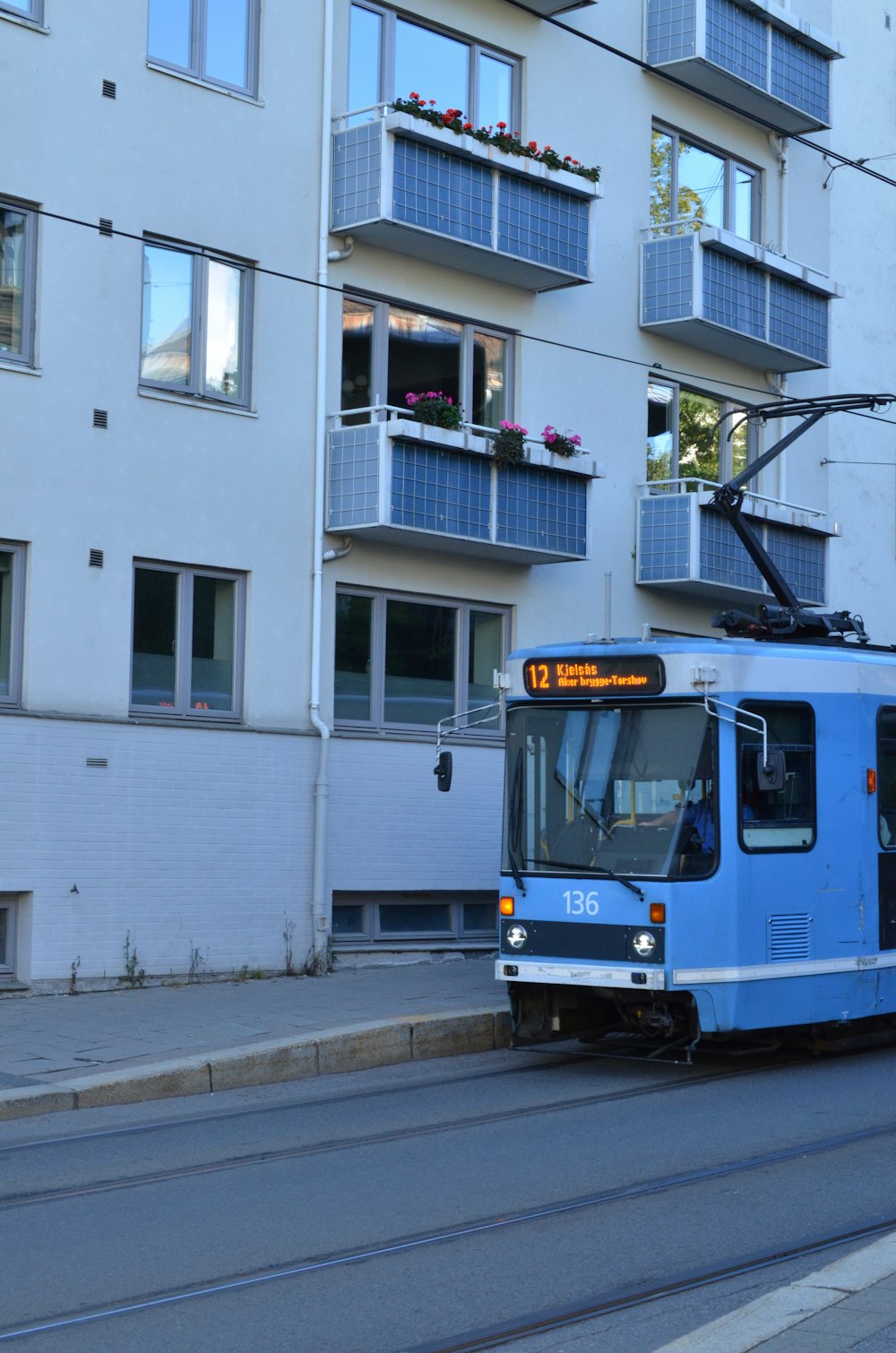 a blue and white trolley on a city street