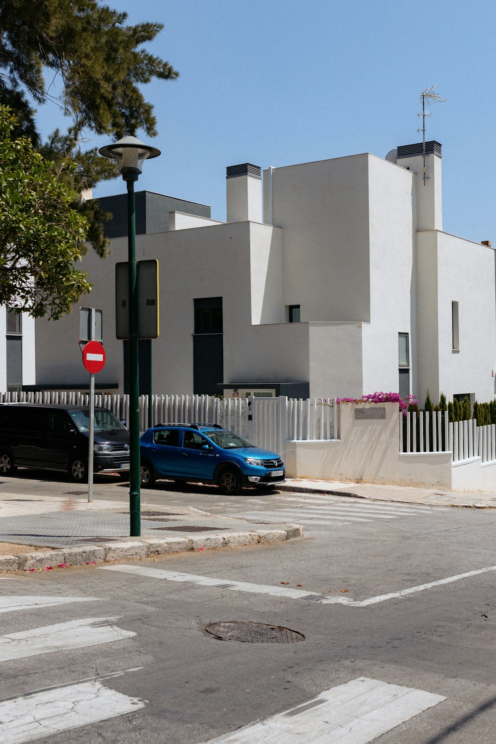 a blue car is parked in front of a white building