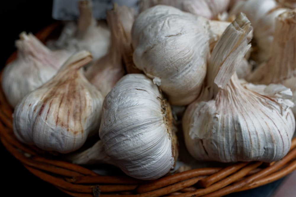 a basket filled with garlic sitting on top of a table