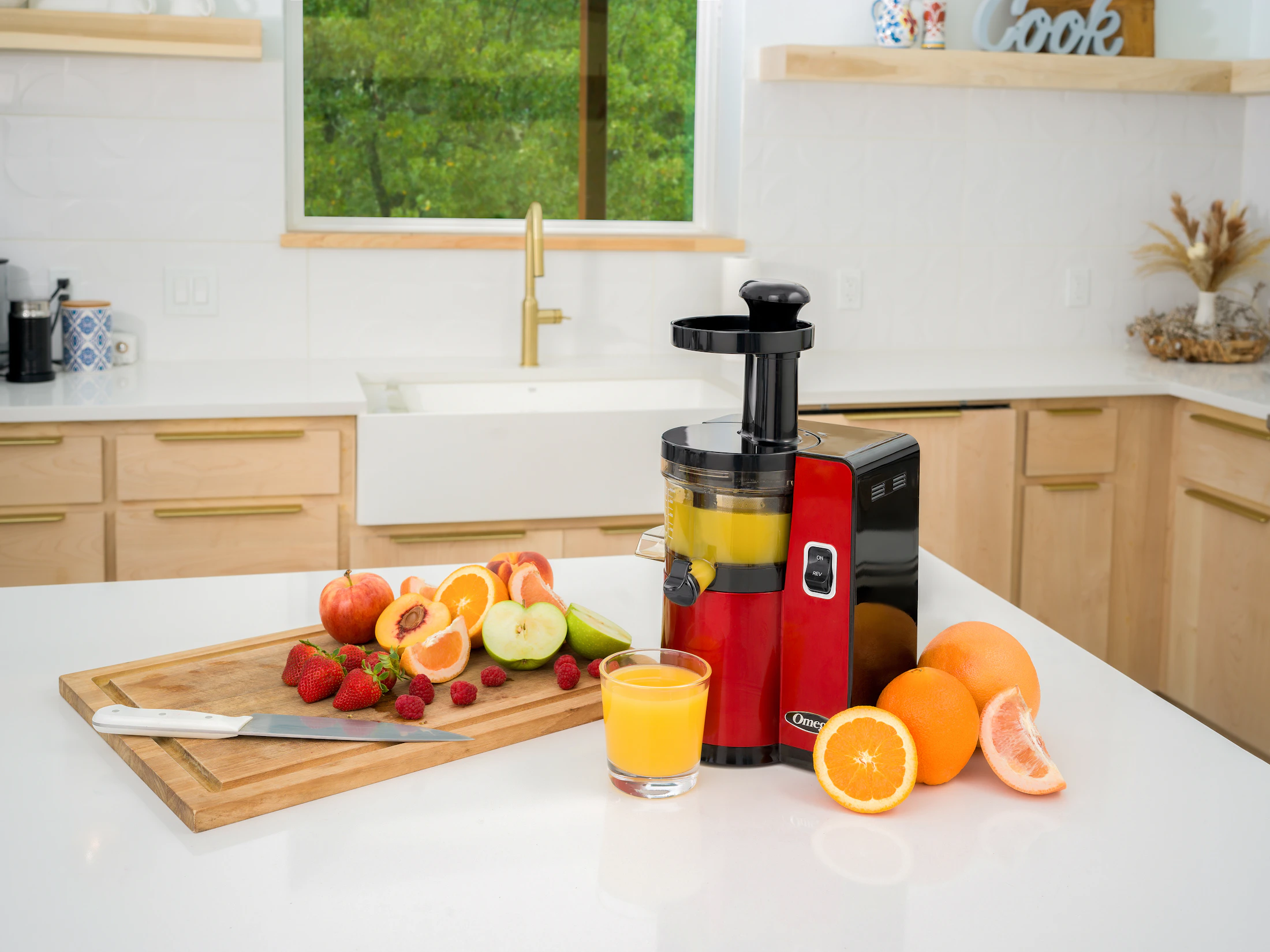 Vertical juicer preparing fresh juice on a clean kitchen island