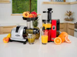 a kitchen counter with a juicer, blender, oranges, and a