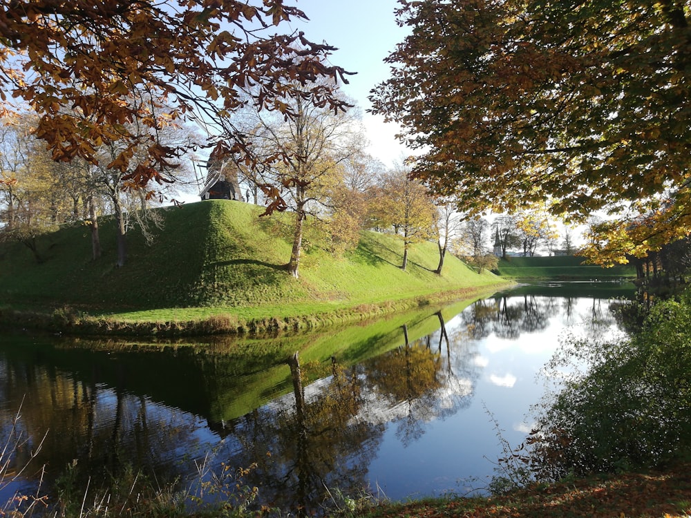 a grassy hill next to a body of water