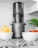 A bright kitchen countertop with a modern juicer and fresh fruits ready for juicing.