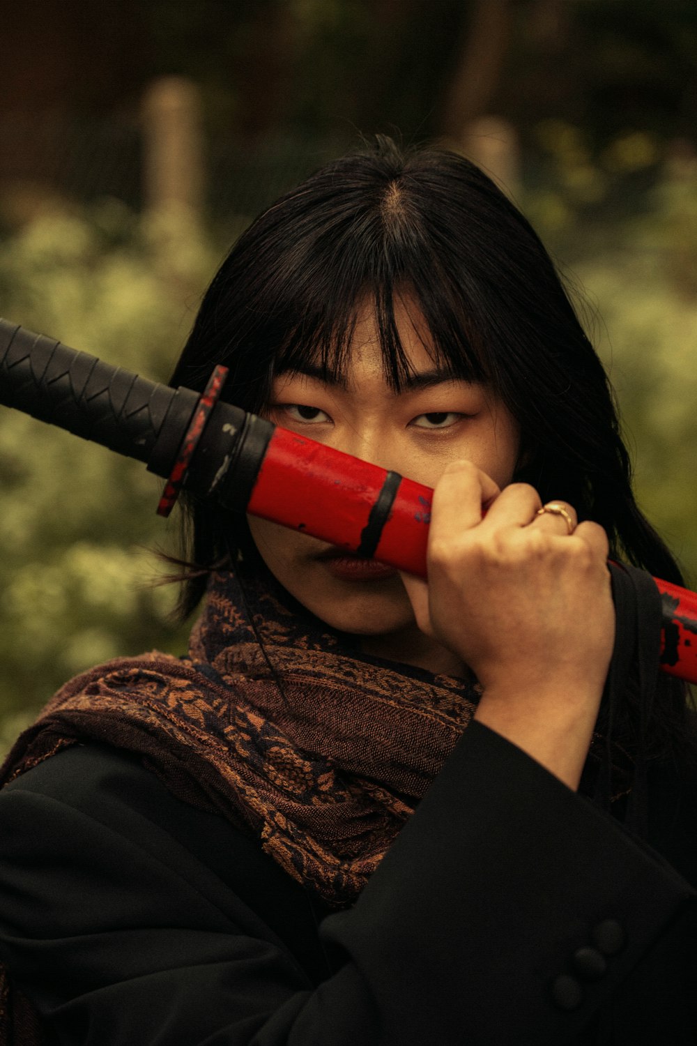 a woman holding a red umbrella over her face