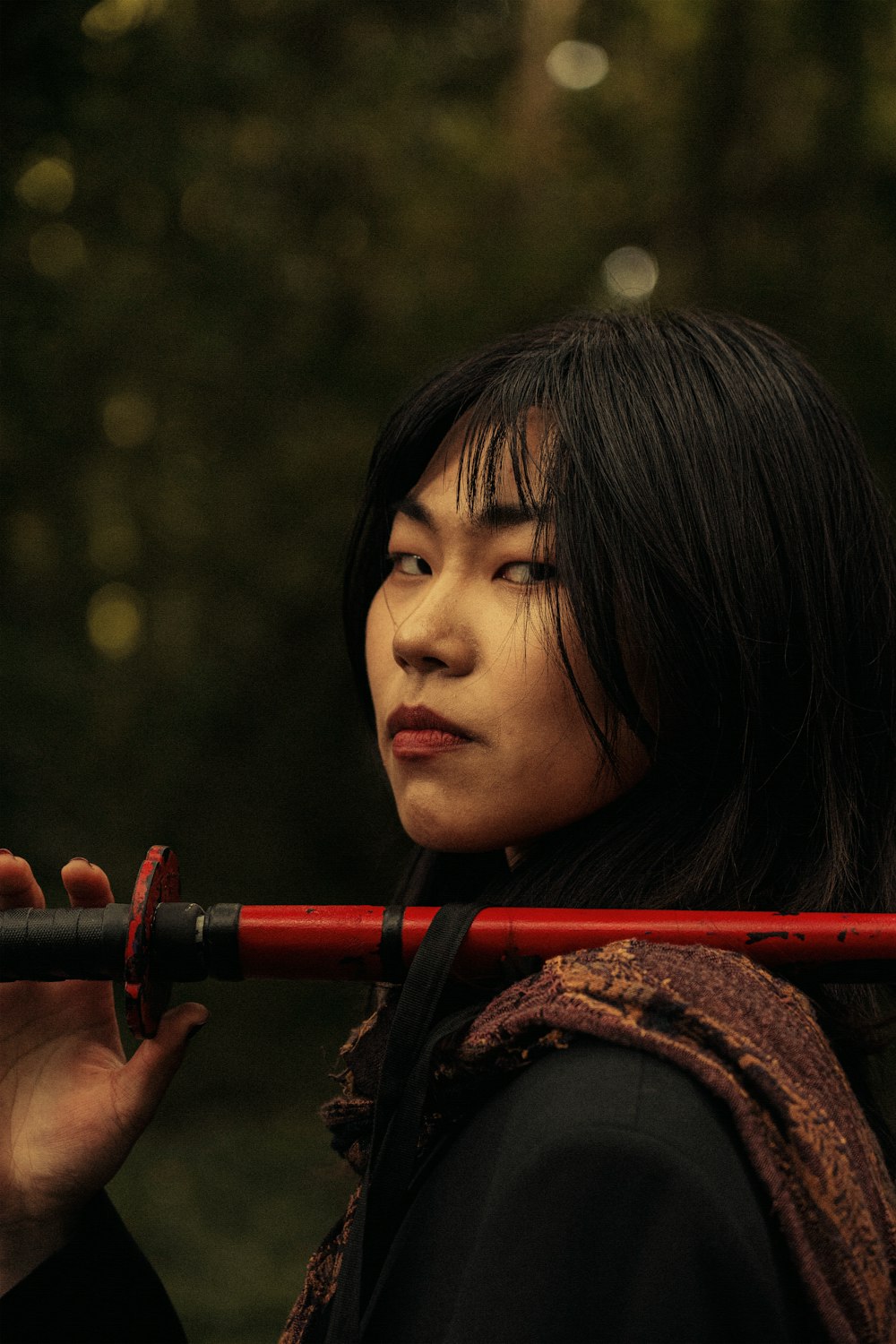 a woman is holding a red stick in her hand