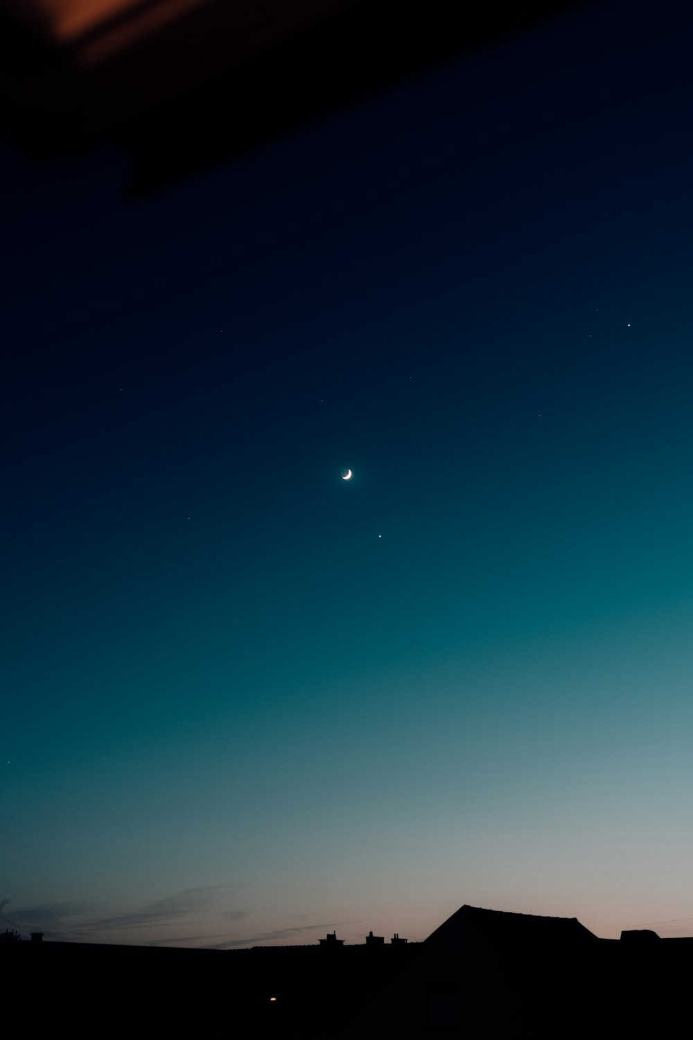 a view of the sky at night with the moon in the distance