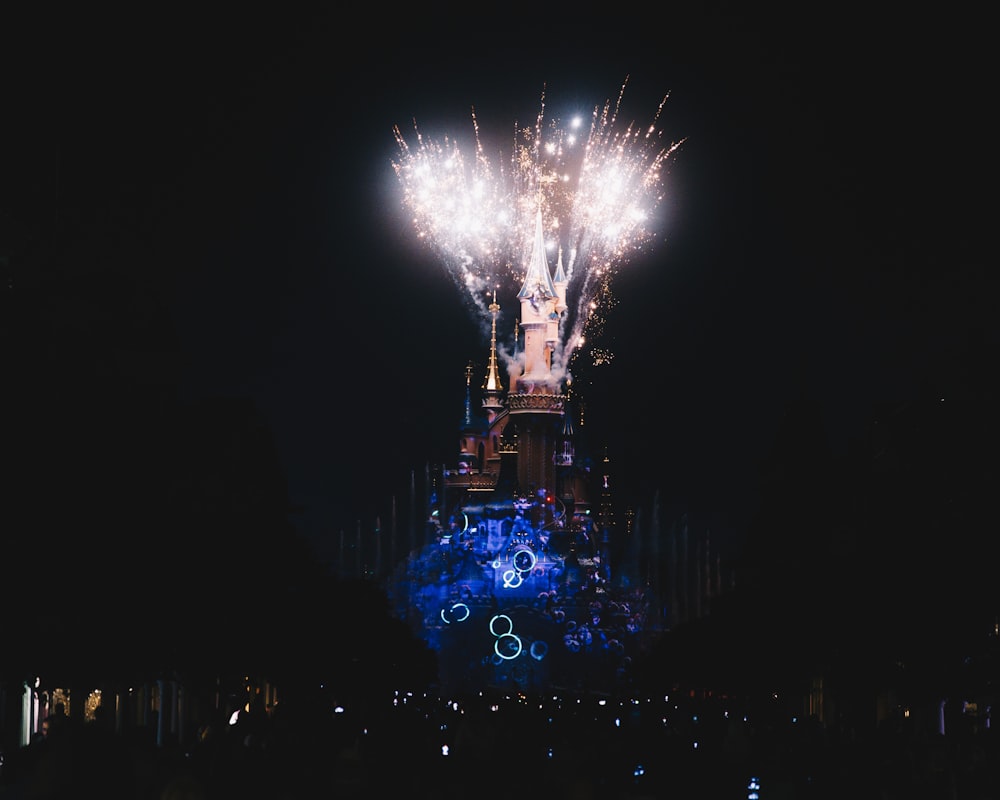 fireworks are lit up in the night sky above a building