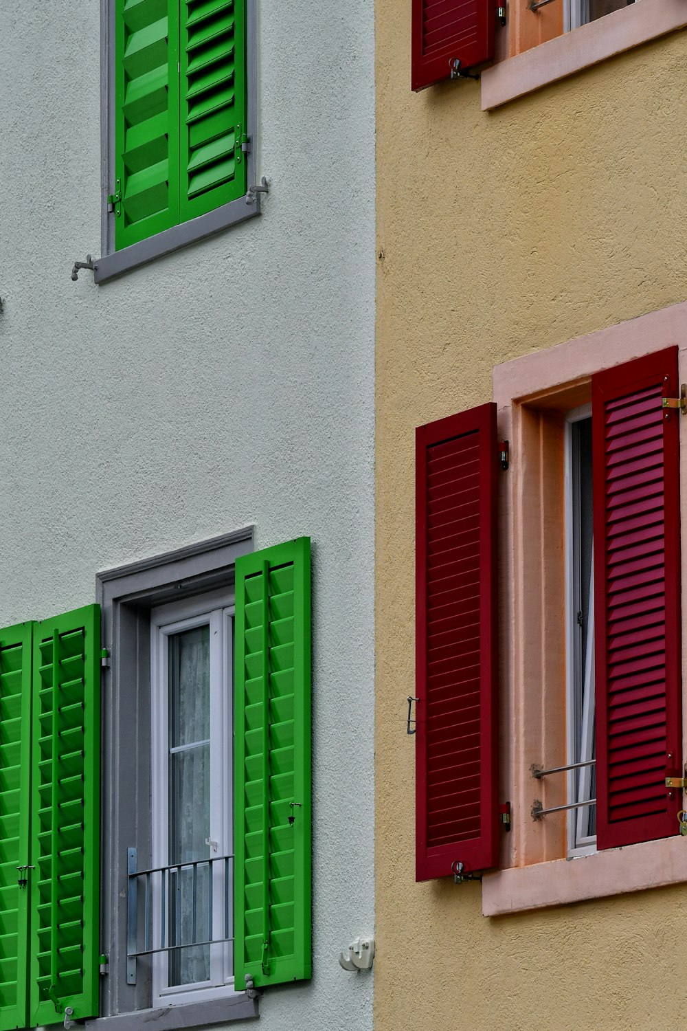 a multicolored building with red and green shutters