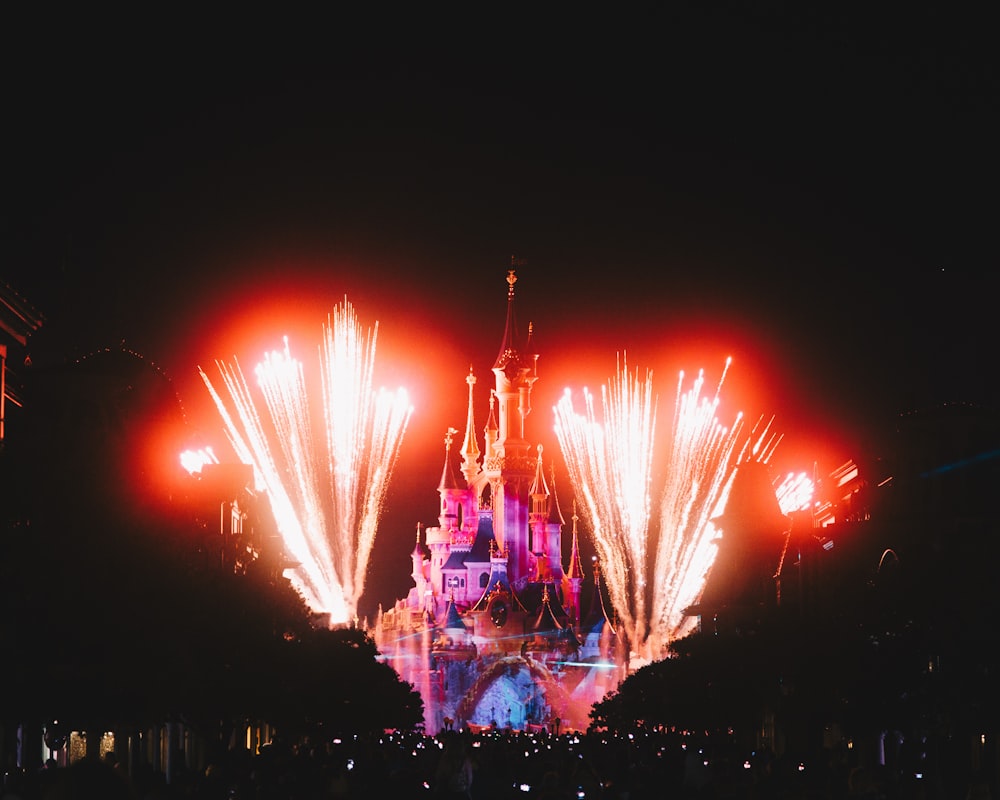 Um castelo iluminado à noite com fogos de artifício