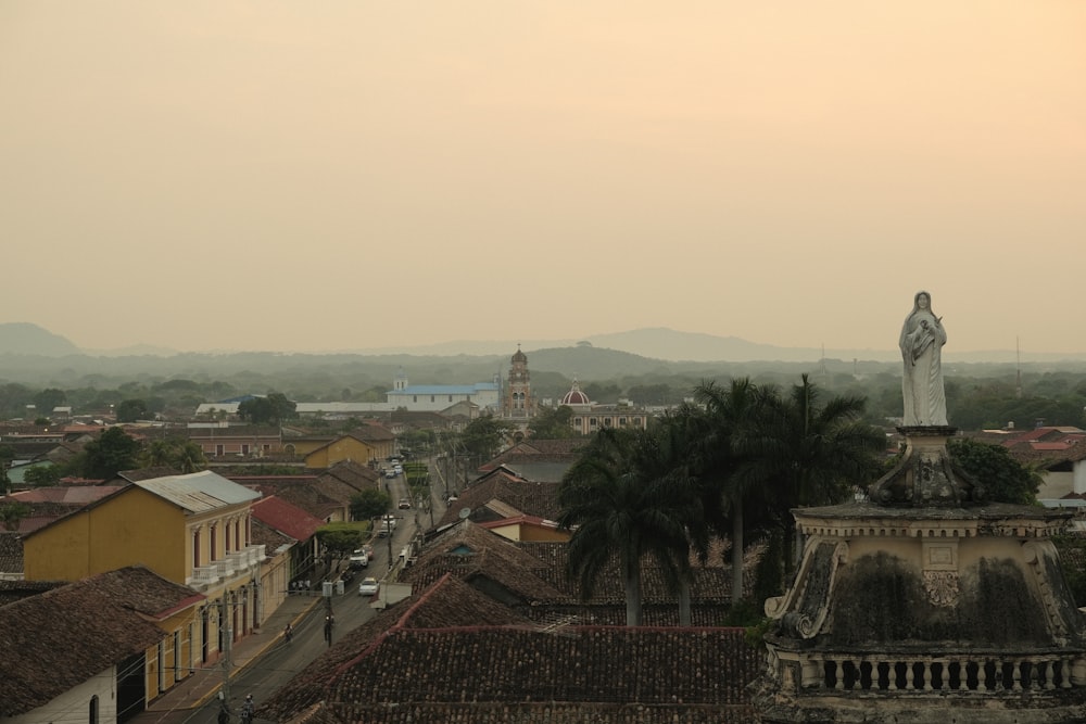 a view of a city with a statue on top of a building