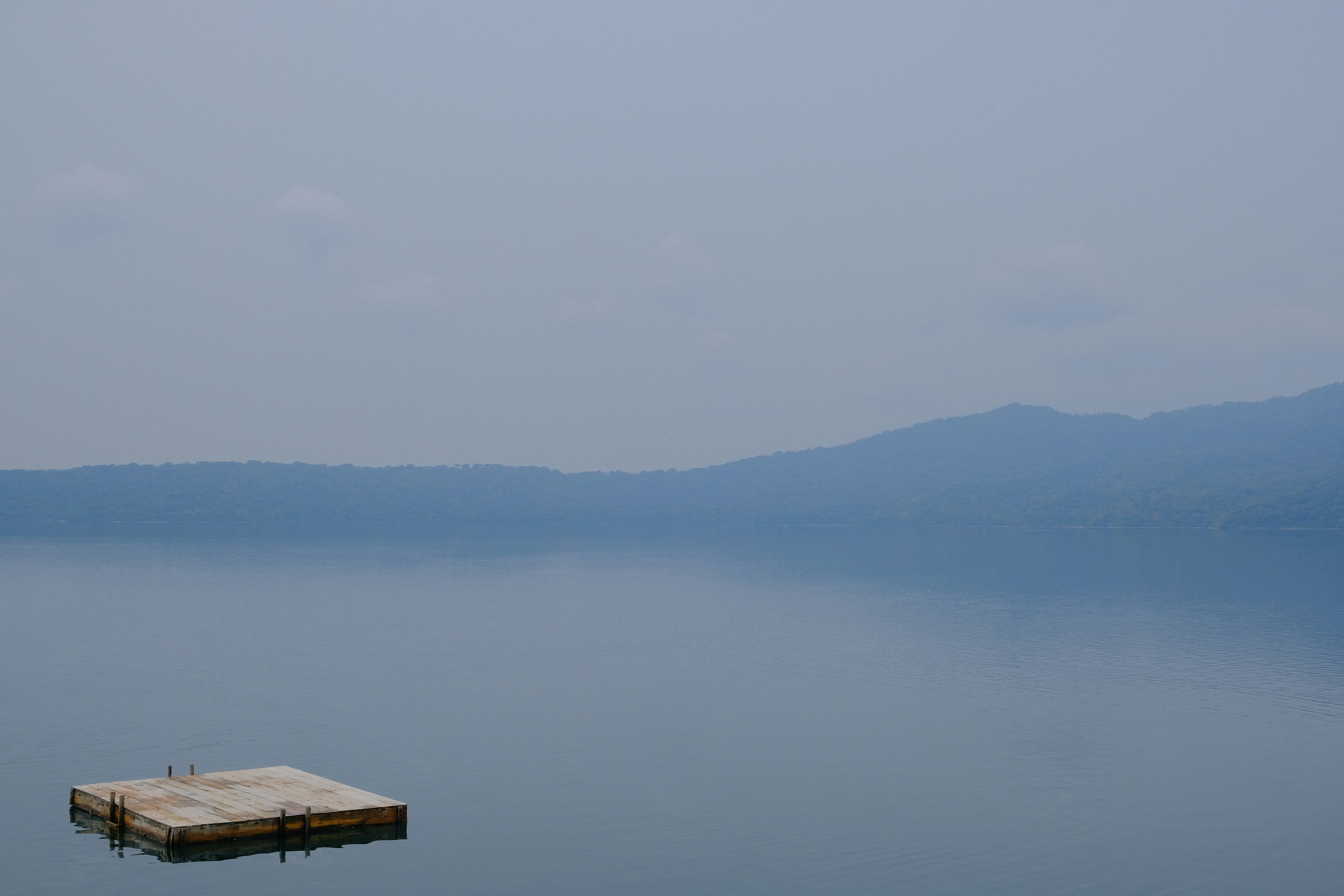 a dock in the middle of a large body of water, Swimming platform at Apoyo Lagoon, Nicaragua. May 2023.