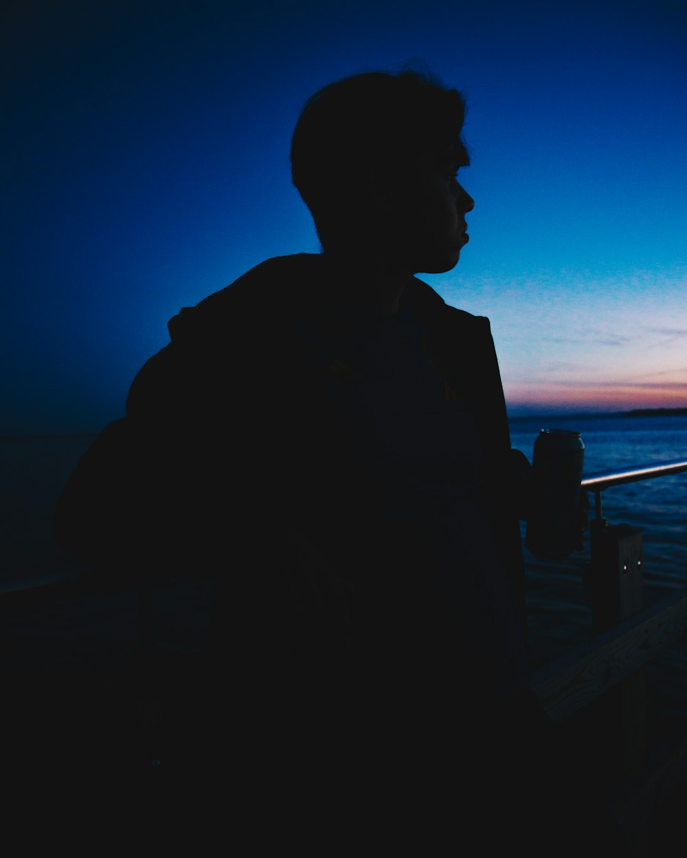 a man sitting on a boat watching the sunset