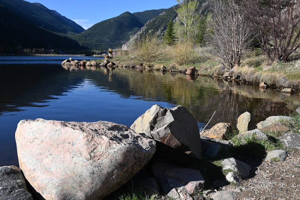 a large rock sitting next to a body of water