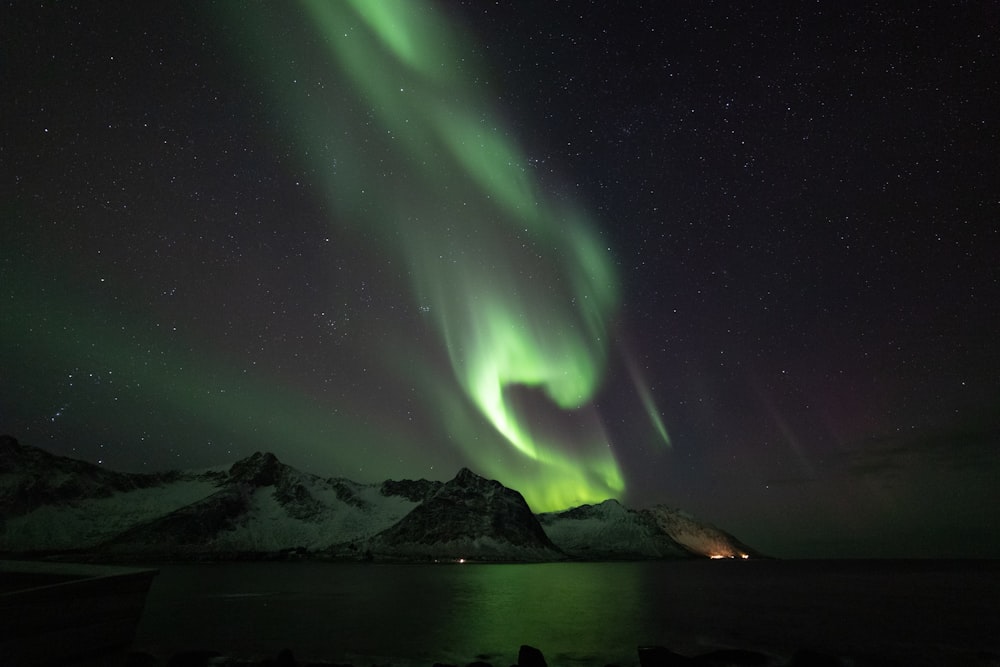 a green and purple aurora over a mountain range