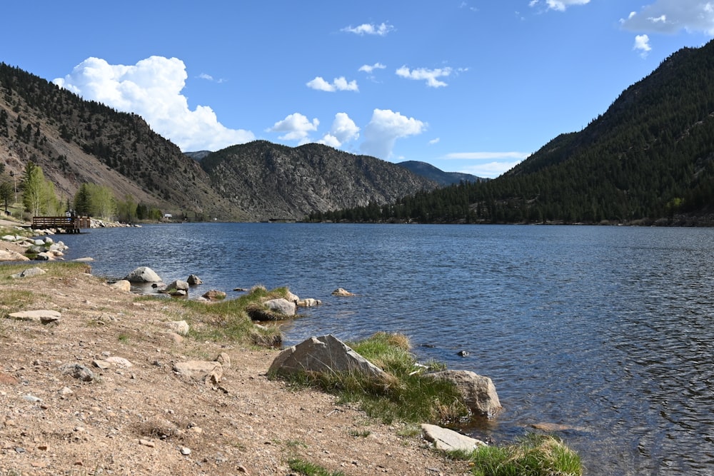 a body of water surrounded by mountains under a blue sky