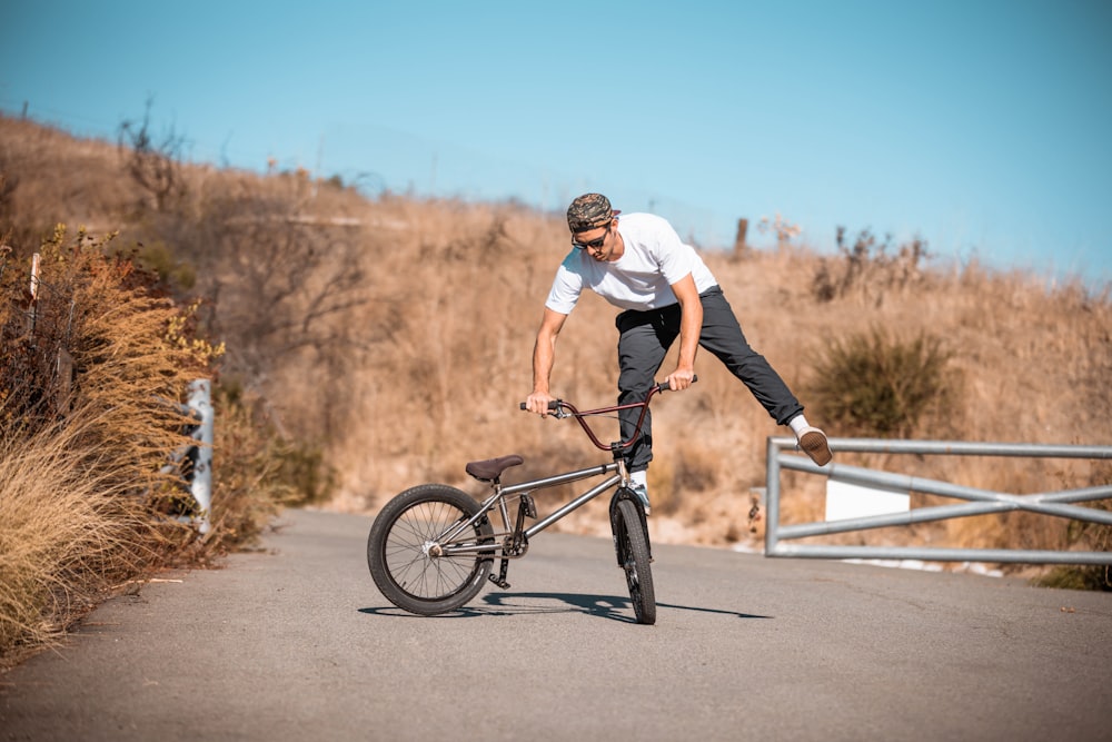 a man doing a trick on a bicycle on a road