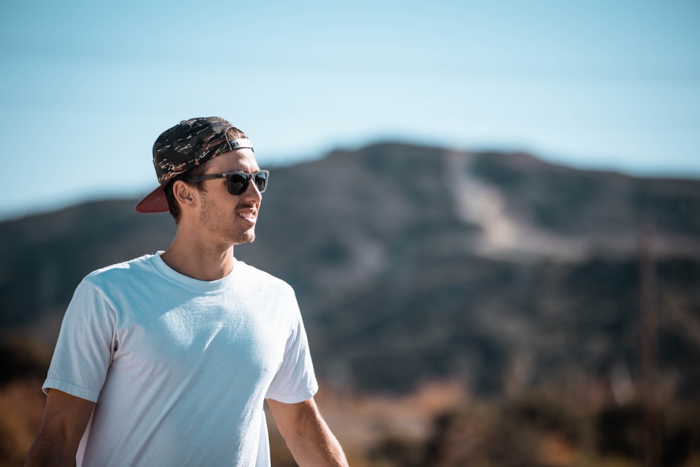 Foto Un hombre con gafas de sol y un pañuelo en la cima de una montaña – Imagen Gafas de sol gratis en