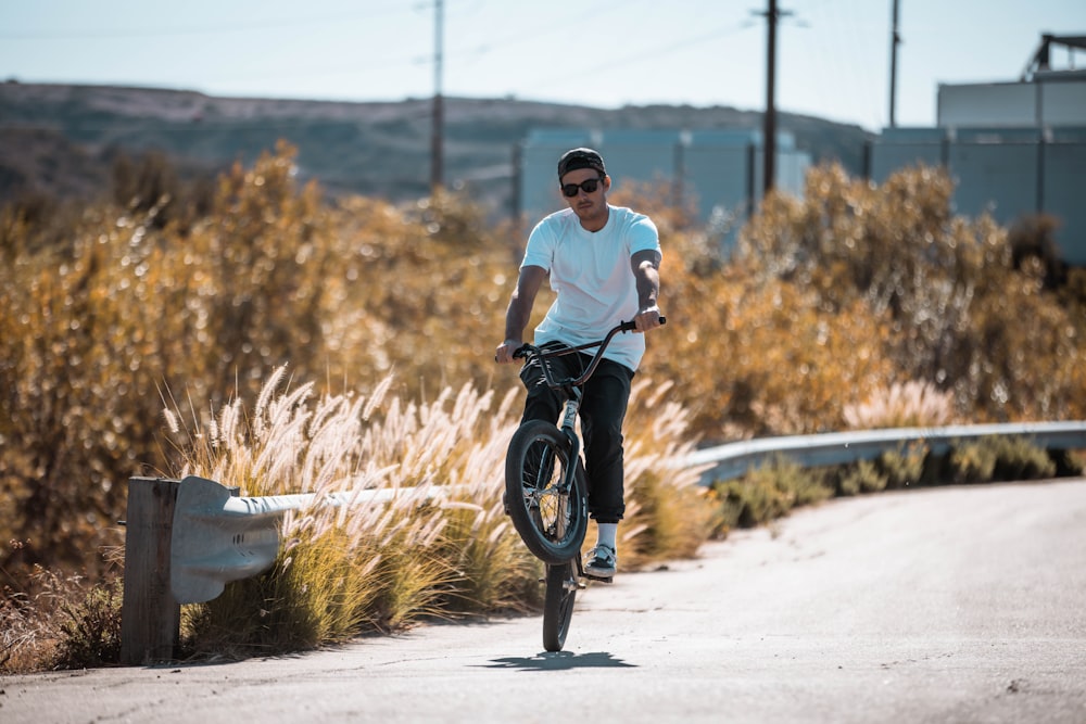 a man riding a bike down a dirt road