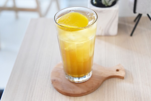 A glass of lemonade sitting on top of a wooden table