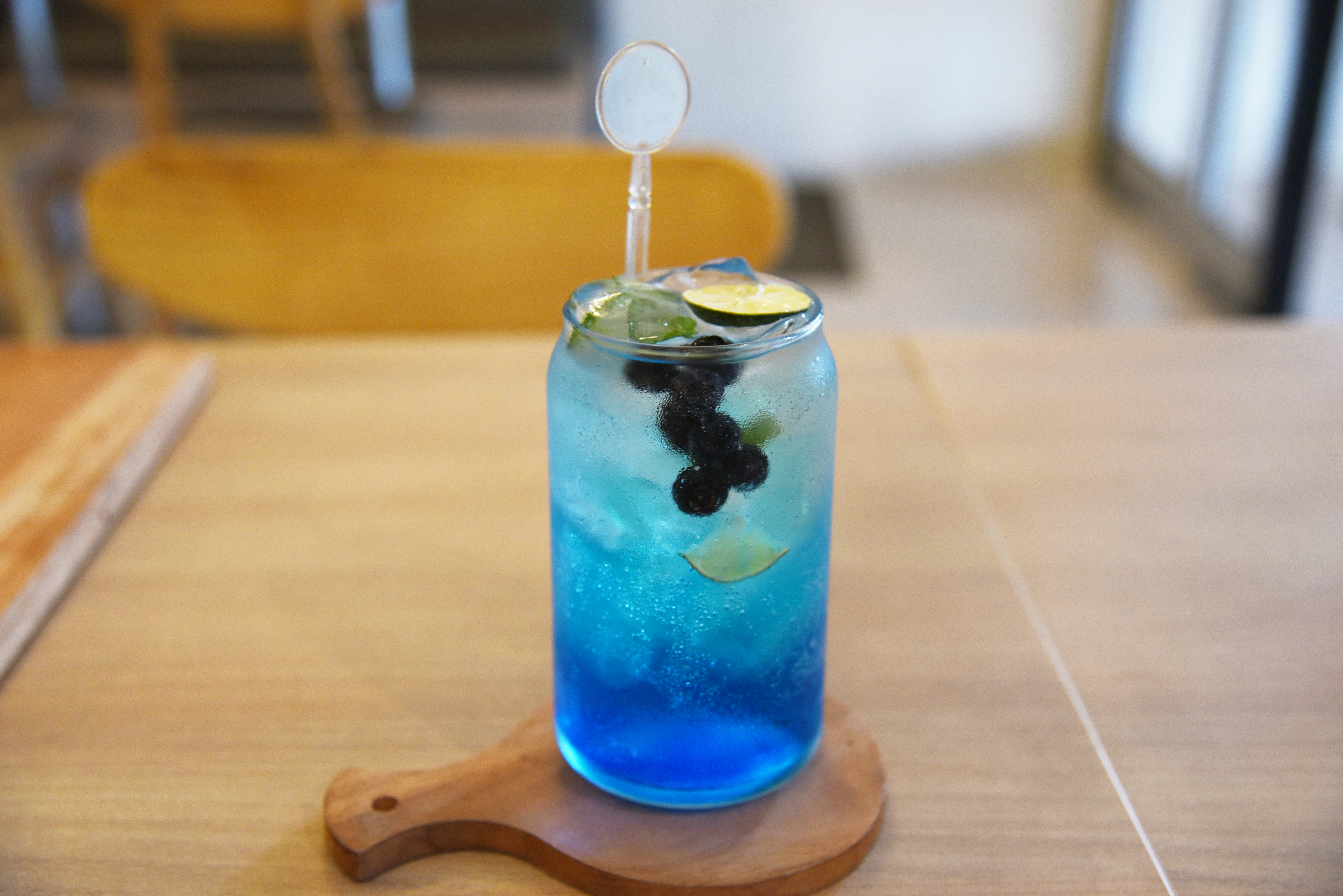 a blue drink with a lime slice in it