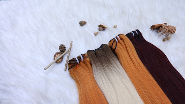 Close-up of a variety of silky hair extensions laid out on a soft fabric background.