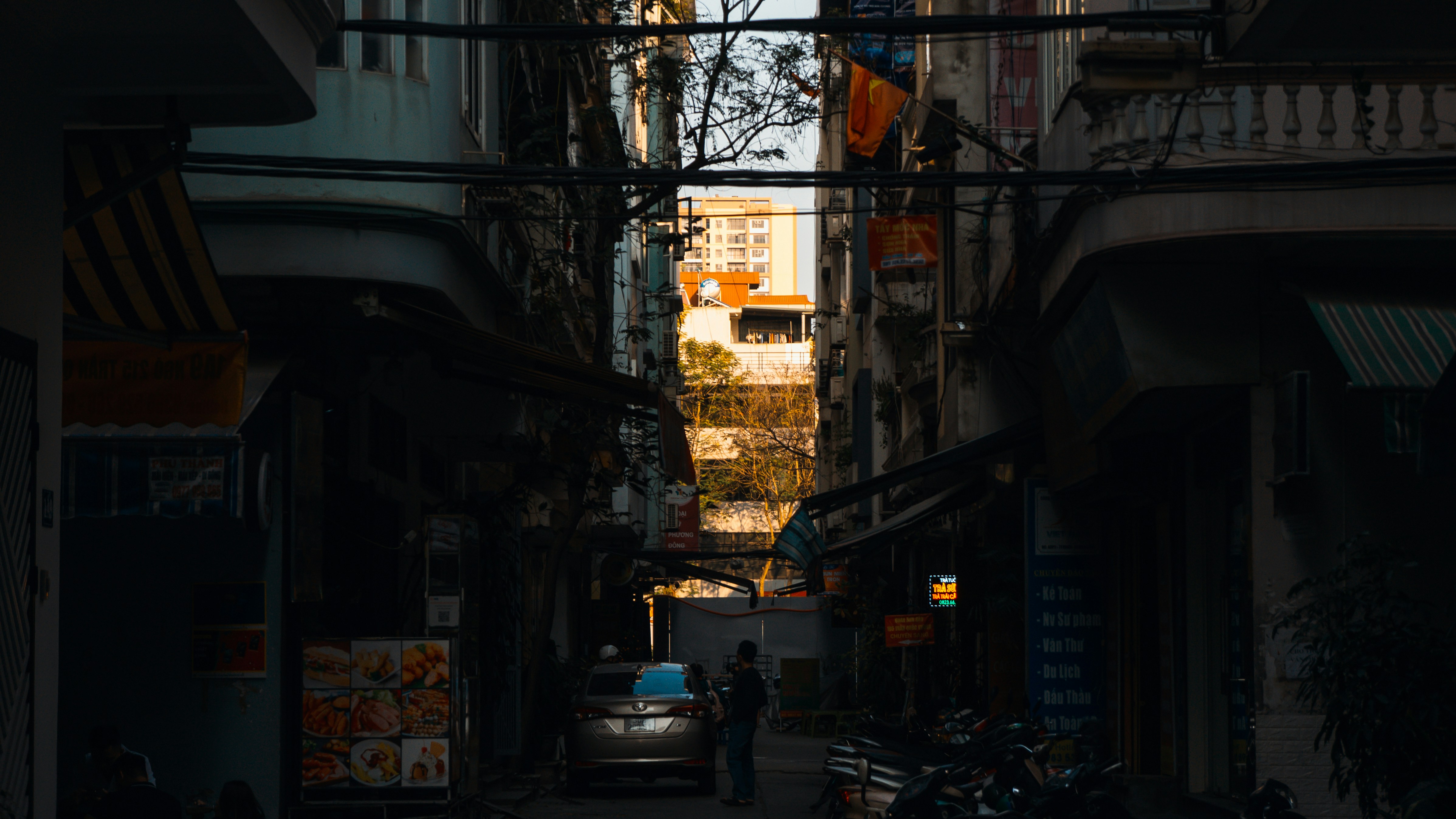 A narrow alley way with a person walking down it