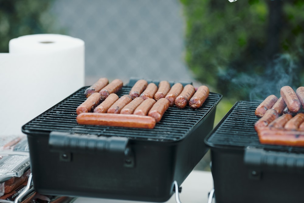 a couple of grills that have some hot dogs on them