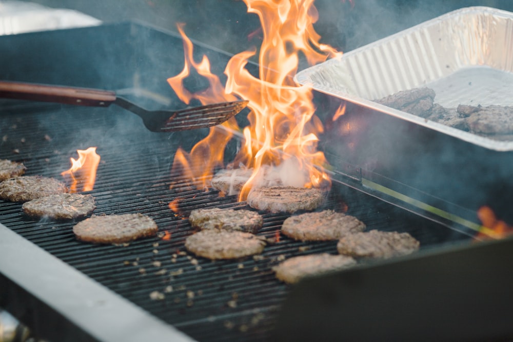a grill with hamburgers and hot dogs cooking on it