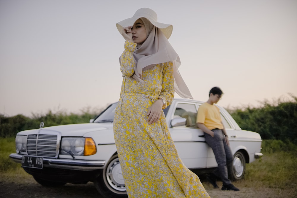 a woman standing next to a white truck