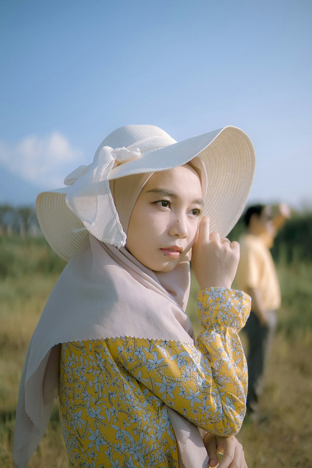 a woman in a yellow dress and a white hat