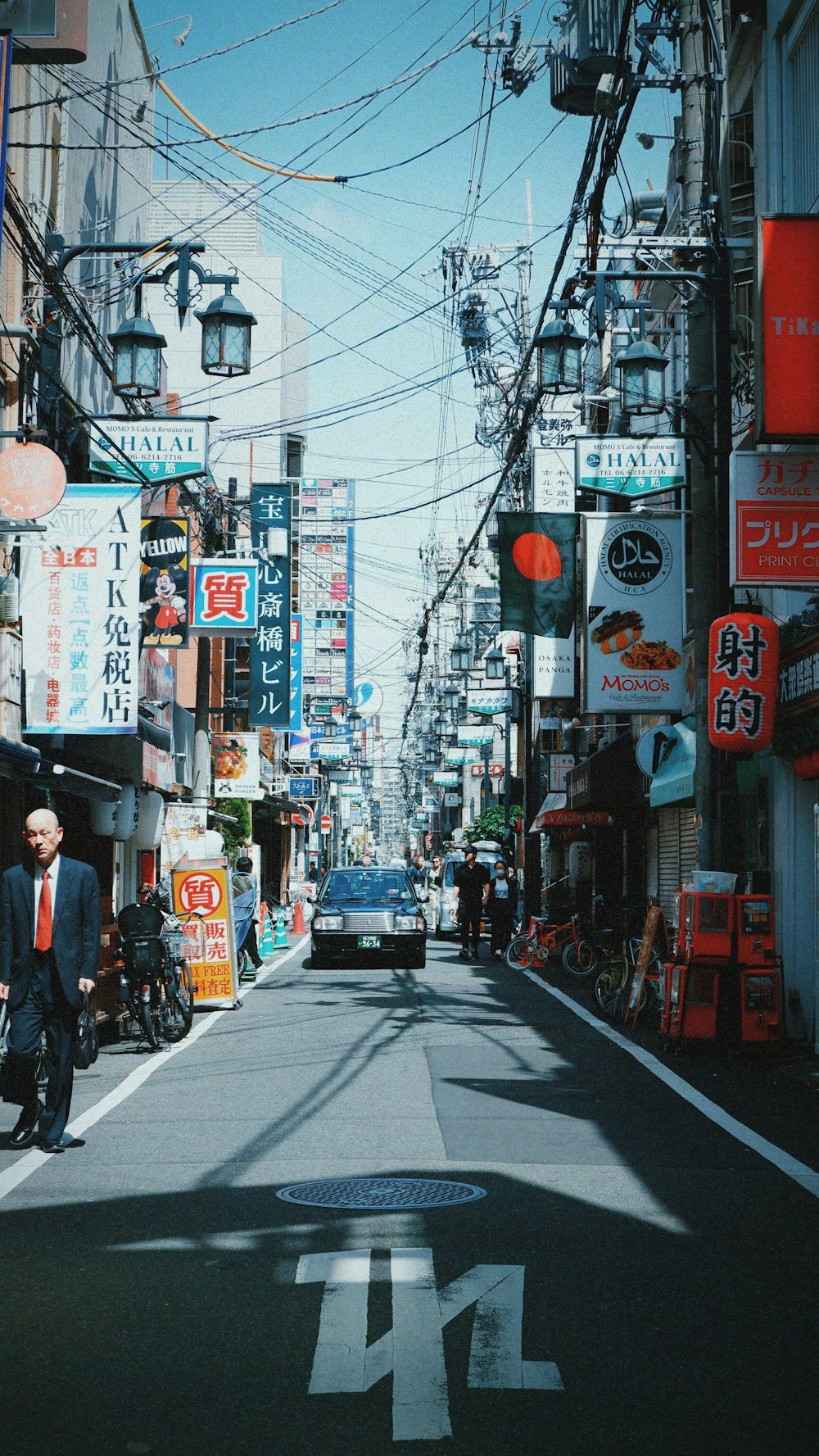 a man in a suit and tie walking down a street