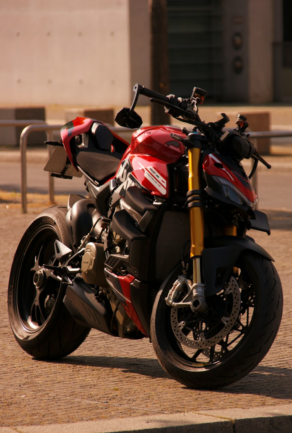 a red and black motorcycle parked on the side of the road