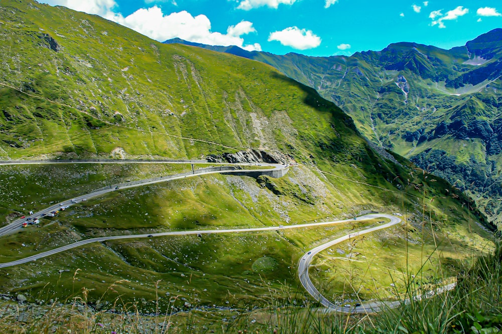 a scenic view of a winding road in the mountains