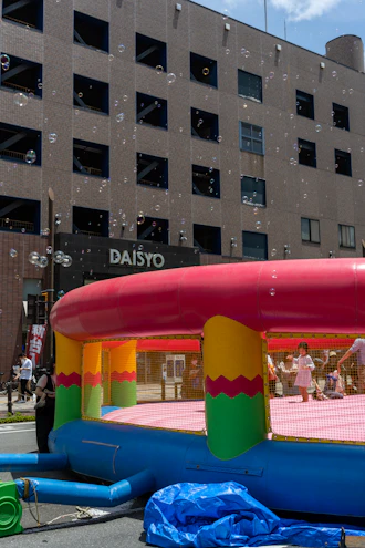 Colorful inflatable bounce houses set up in a sunny backyard party scene