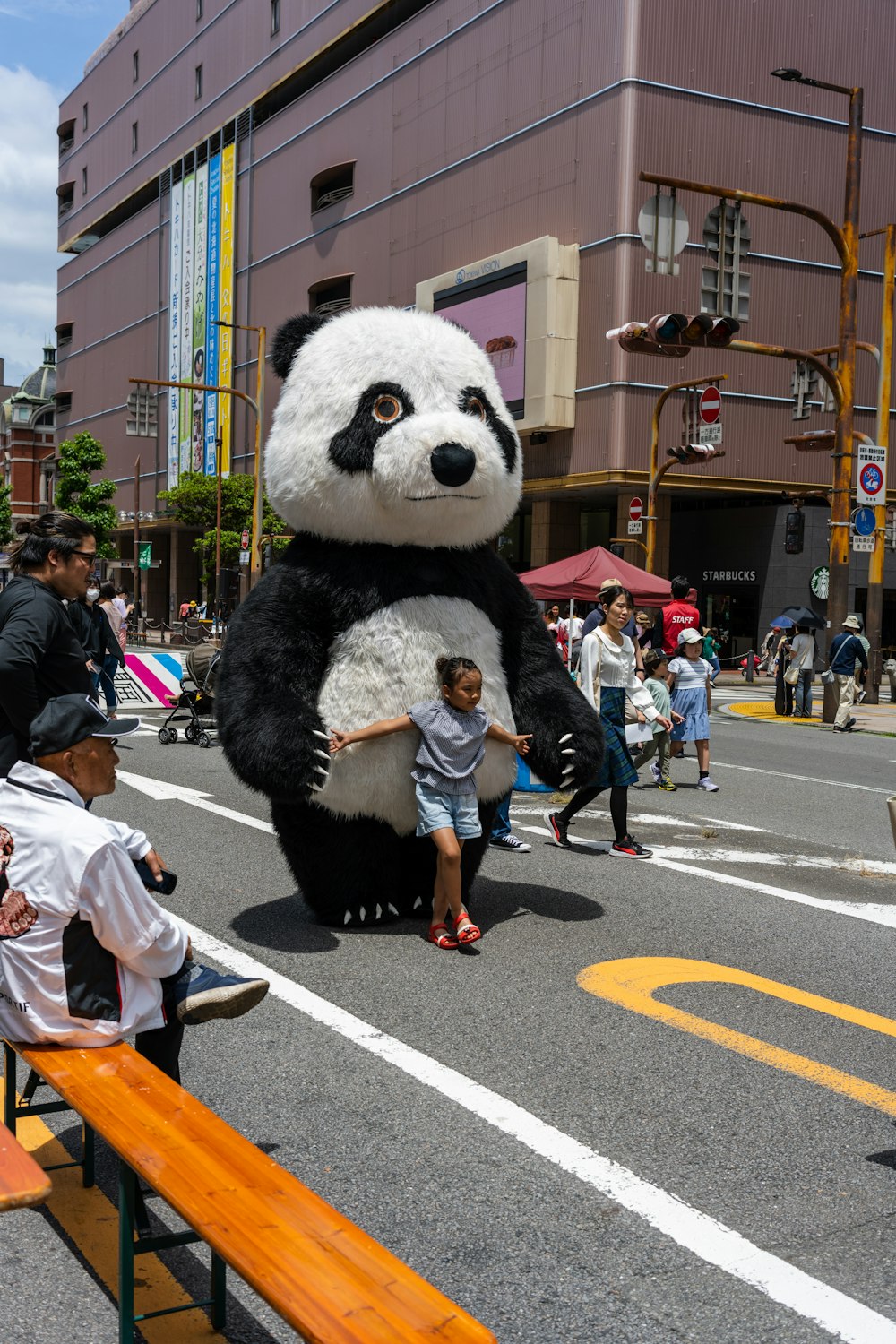 a giant panda bear standing in the middle of a street