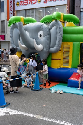 Children enjoying a colorful inflatable bull riding game at a festive event.