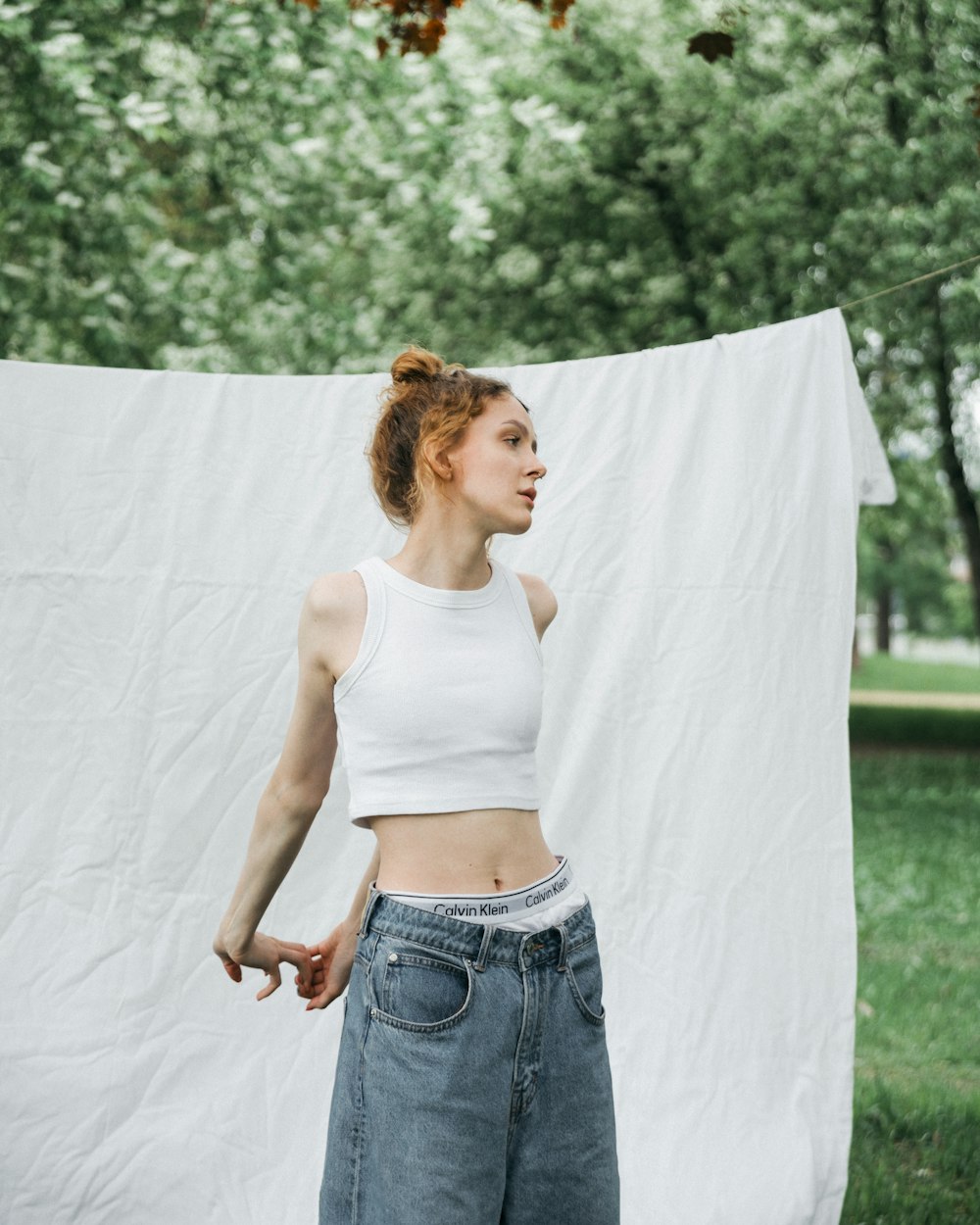 a woman standing in front of a white sheet